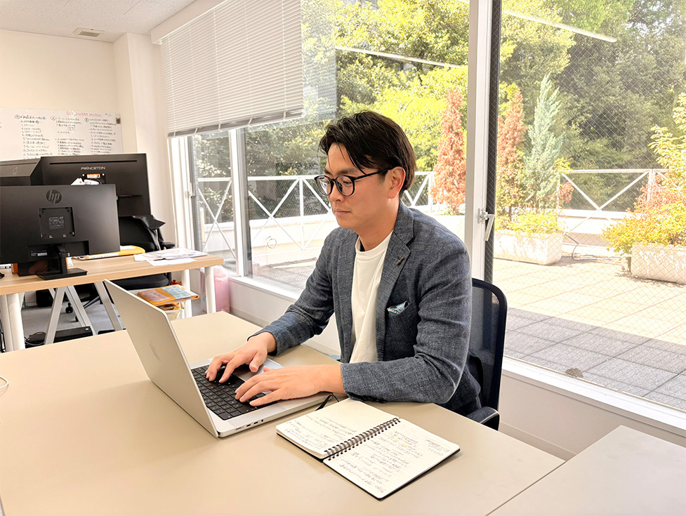 オフィスでPC作業を行うスタッフとCOOKPITの事業紹介イメージ